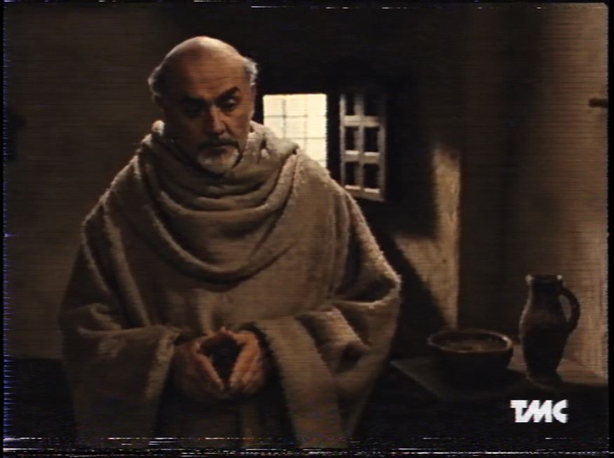 Fotogramma VHS de Il nome della rosa trasmesso da TMC, con Sean Connery nei panni di Guglielmo da Baskerville e il logo TMC in basso a destra.